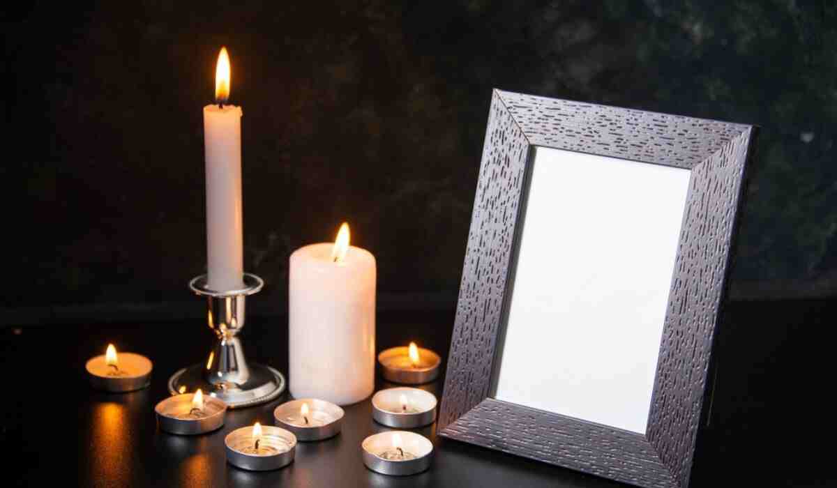 Memorial setup with candles and an empty picture frame, symbolizing remembrance.